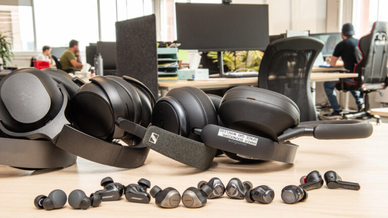 Person wearing Bose QuietComfort Ultra Headphones while working on a computer in a modern office setting.